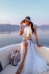 A lady wearing a stunning Tshwane geometric-patterned print dress with a dramatic white tulle skirt, on a boat ride in Hartebeespoort Dam.