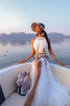 A lady wearing a stunning Tshwane geometric-patterned print dress with a dramatic white tulle skirt, on a boat ride in Hartebeespoort Dam.